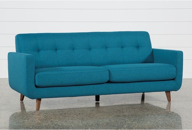 a blue couch sitting on top of a cement floor