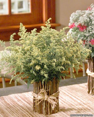 two vases filled with flowers sitting on top of a wooden table next to each other