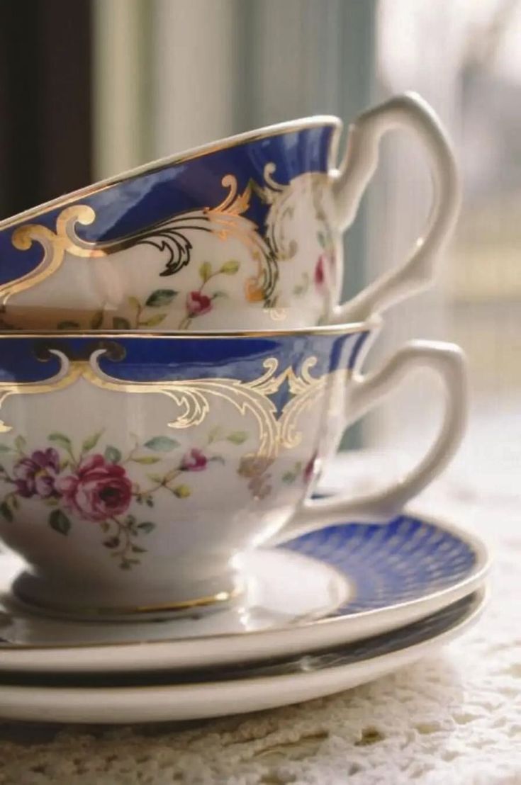 two cups and saucers sitting on top of a table