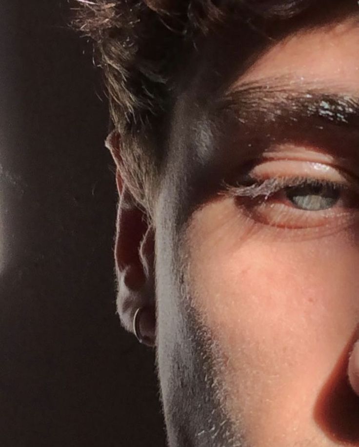 a close up of a man's face with the sun shining through his eyes