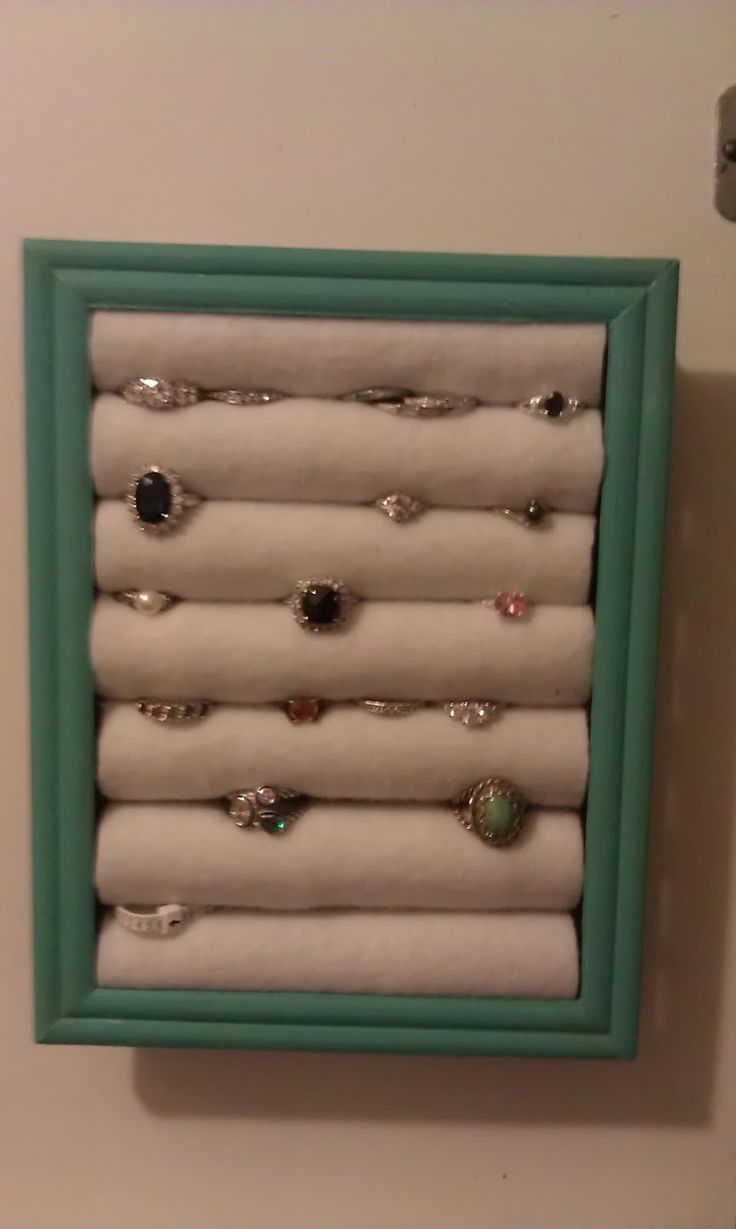 a green frame holds several pairs of rings and napkins in the shape of a ring holder