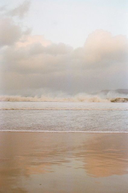 a person riding a surfboard on top of a sandy beach