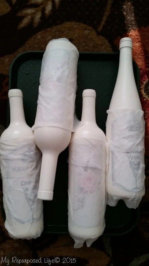 three bottles are wrapped in toilet paper and sitting next to each other on a tray