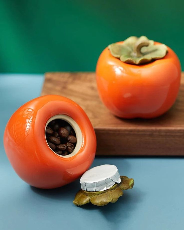 there are two tomatoes on the cutting board and one has seeds in it, while the other is half eaten