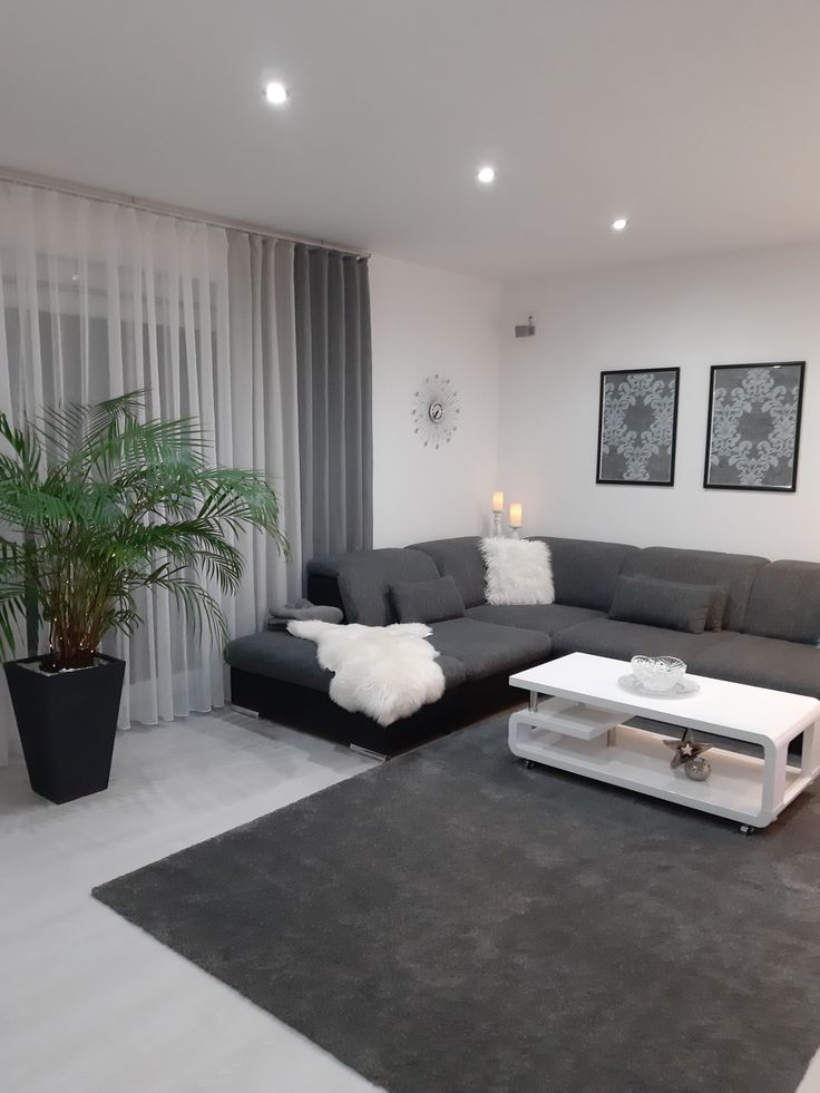 a living room with grey couches and white coffee table