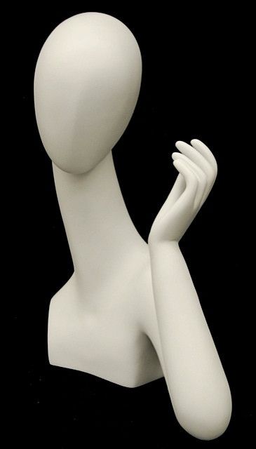 a white mannequin holding its hand up to the side on a black background