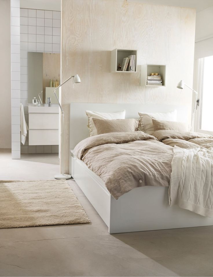 a bed room with a neatly made bed and a night stand on the wall next to it