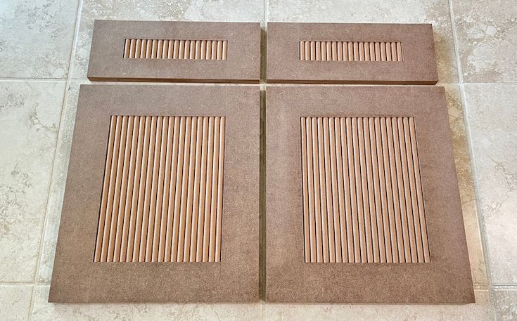 four pieces of cardboard sitting on top of a tile floor