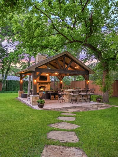 an outdoor kitchen and grill in the middle of a yard