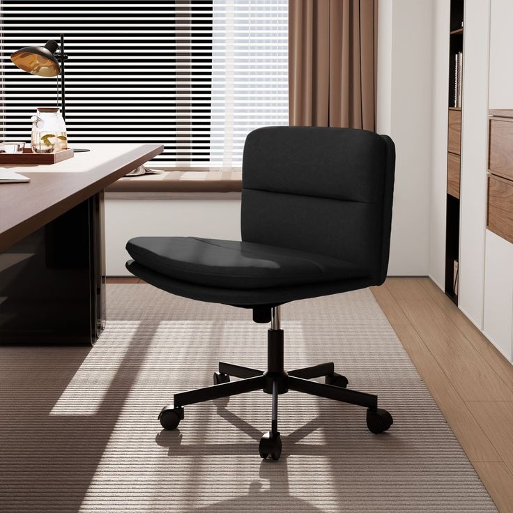 a black office chair sitting in front of a window