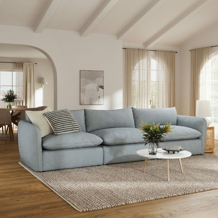 a living room filled with furniture and a large rug on top of a hard wood floor