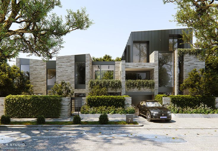 a car parked in front of a building with trees and bushes on the side of it