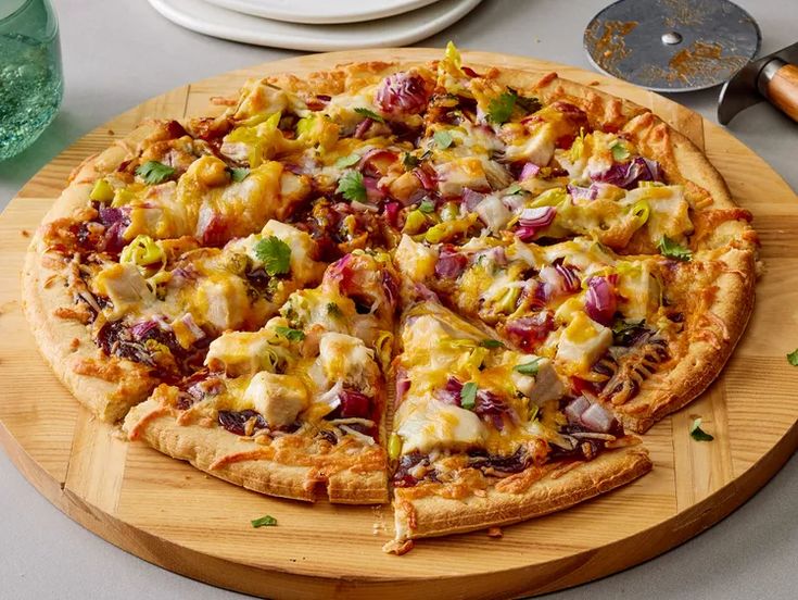 a pizza sitting on top of a wooden cutting board