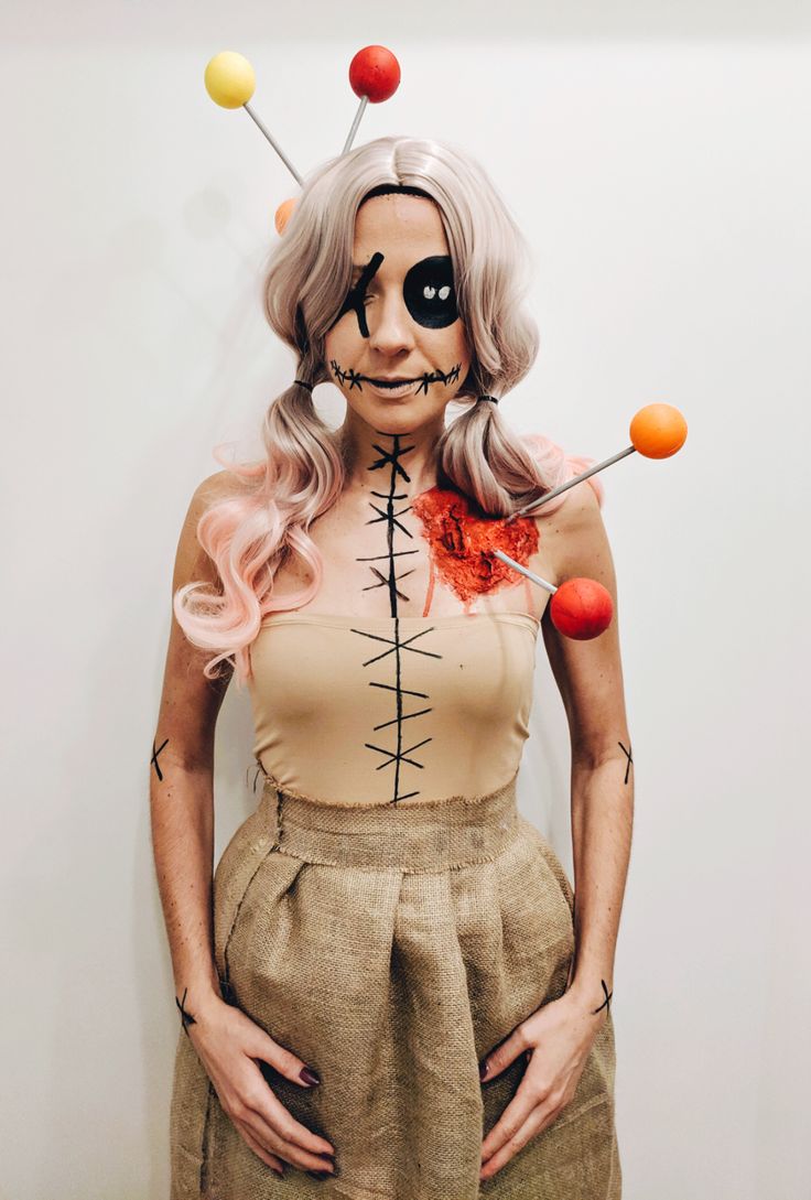 a woman with long hair and makeup is dressed up as a skeleton holding pins in her mouth