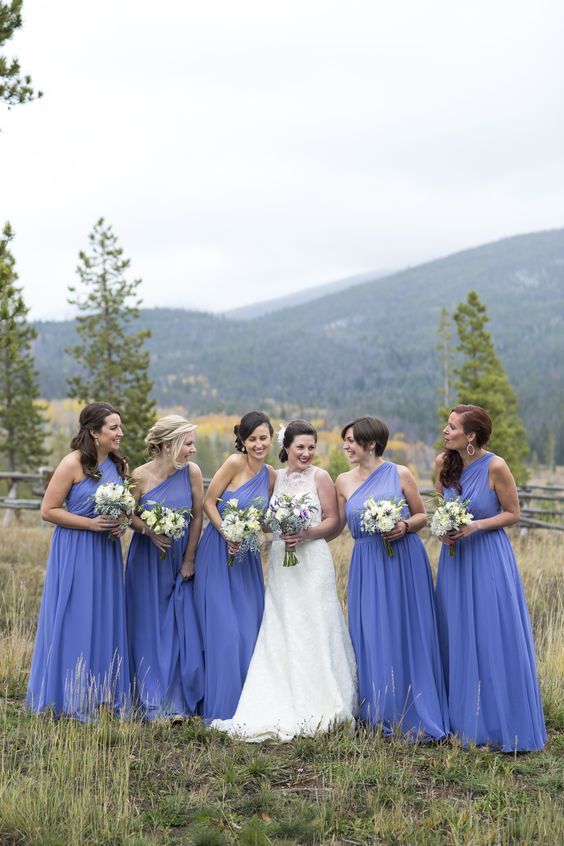 a group of women standing next to each other on top of a grass covered field