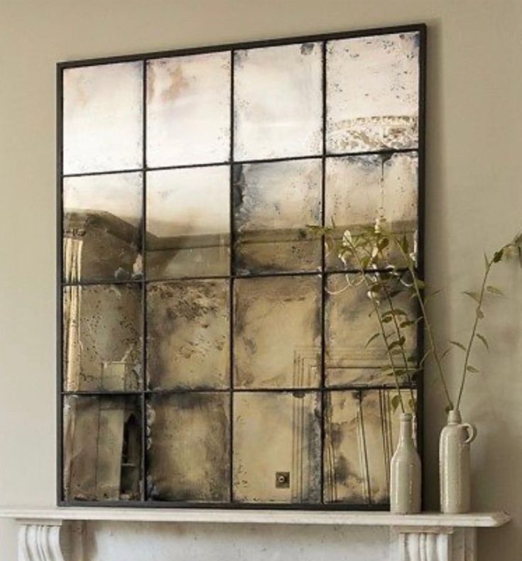 a living room filled with furniture and a fire place under a large mirror on the wall