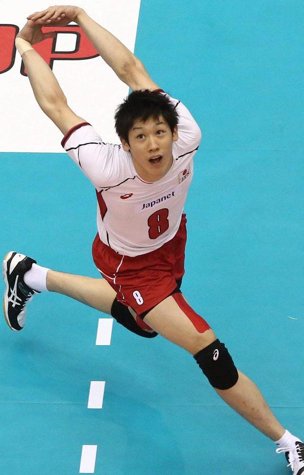 a man in red shorts and white shirt playing volleyball