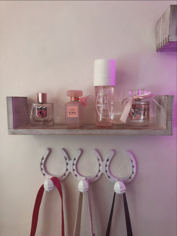 three pairs of scissors are hanging on a shelf with perfume bottles and other items in the background