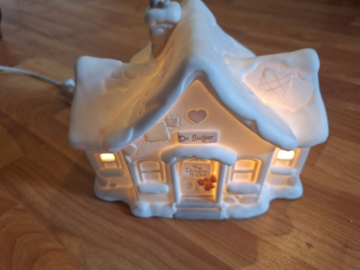 a white ceramic house with lights on it