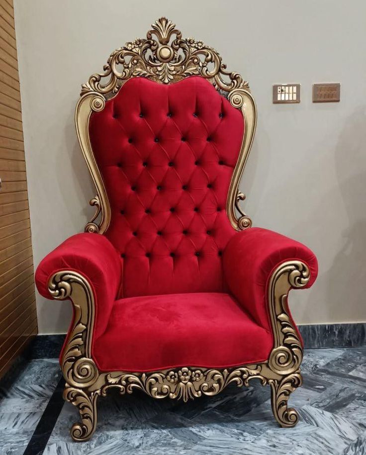 a red chair with gold trim in a room