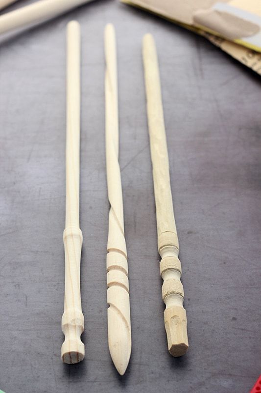 three wooden spoons are sitting next to each other on a table with some knitting needles