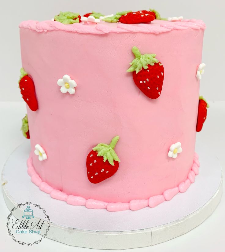 a pink cake decorated with strawberries and daisies