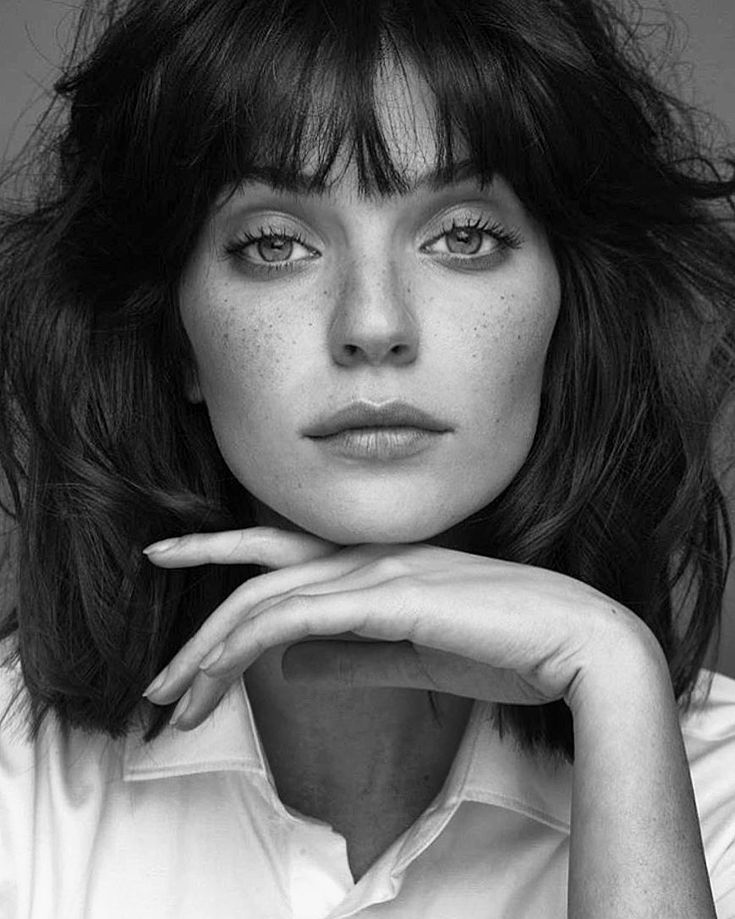 a black and white photo of a woman with freckles on her hair looking at the camera