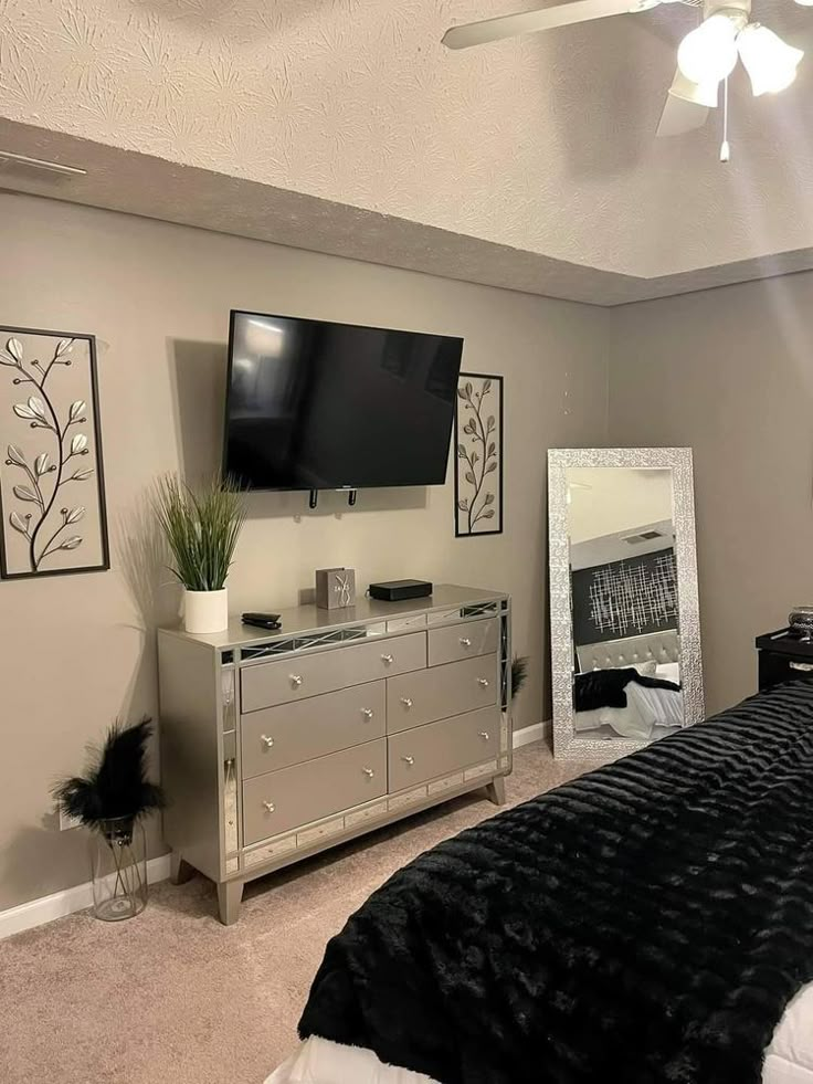 a bed room with a neatly made bed and a flat screen tv on the wall