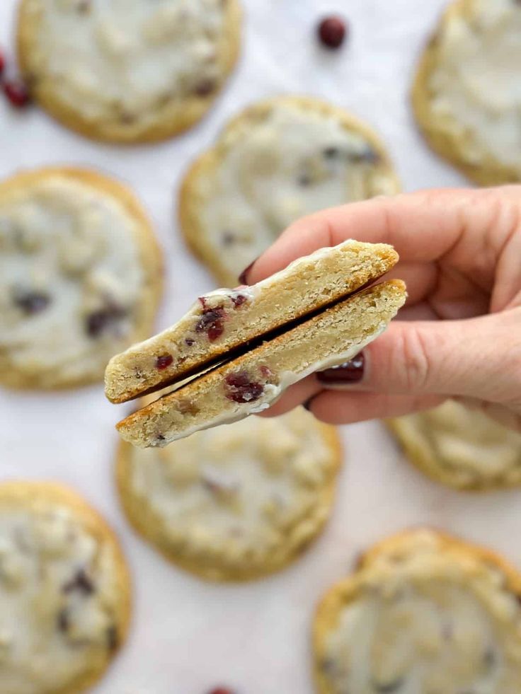 a hand holding a biscuit with cranberries on it