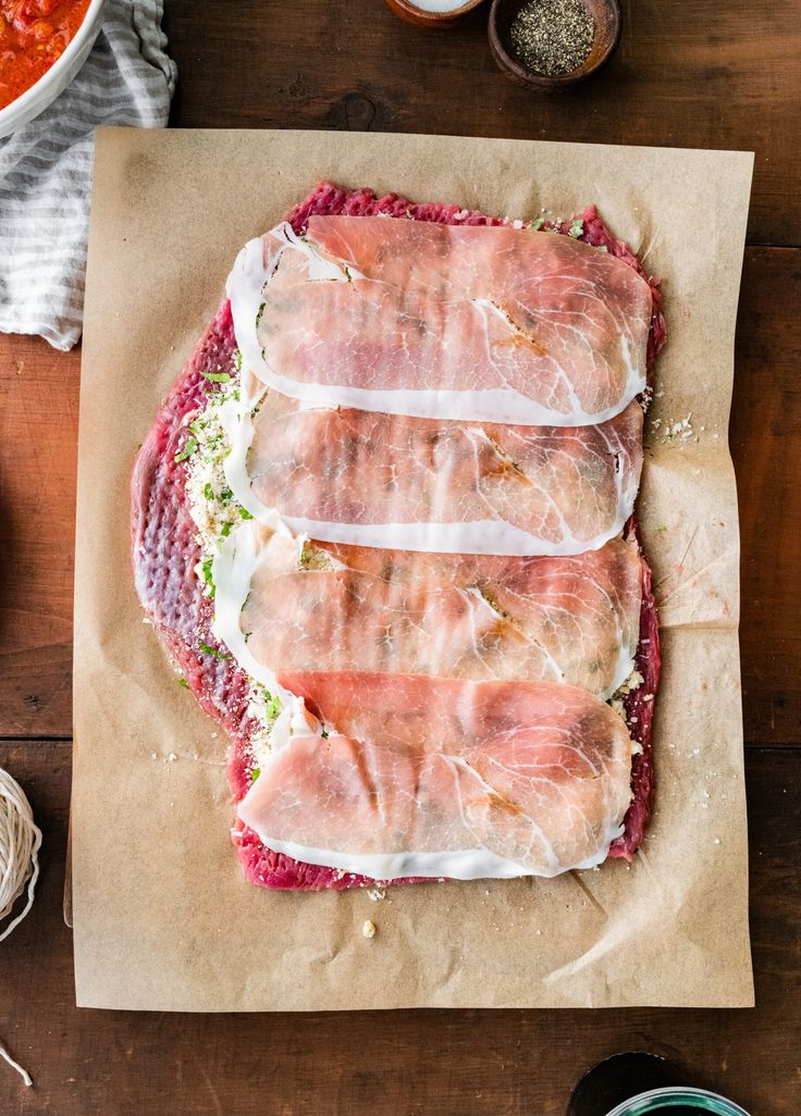 raw meats are laid out on top of wax paper and ready to be cooked