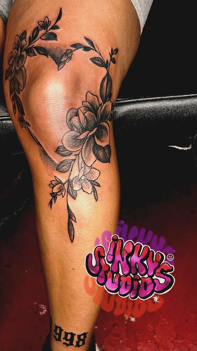 a woman's leg with flowers on it and the word love written in black ink