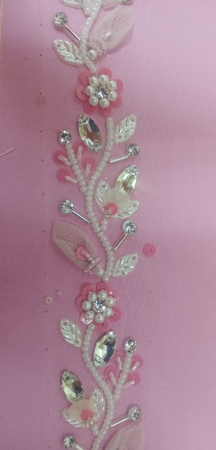 a pink wall hanging with flowers and hair clips