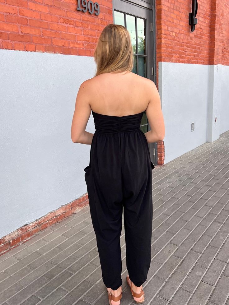 This jumpsuit has viral style written all over it! Slip into the Bowie Jumpsuit to be not only comfy, but ultra-stylish! Style with your favorite sandals for an everyday comfortable look or dress it up with a moto jacket & some heels! black strapless jumpsuit ruched bust drop crotch front pockets elastic hem soft, stretchy material! (you will want to live in this!) SIZING: Runs true to size! Mary Kate is wearing a size small, she typically wears a 4/Small in most items & is 5'8"!Small ~ US Size Medium Wash Fitted Strapless Jumpsuit Casual, Compressive Sleeveless Jumpsuit With Built-in Bra, Casual Black Jumpsuit With Built-in Bra, Black Jumpsuits With Built-in Bra And High Stretch, Black Strapless Jumpsuit, Chic Black Non-stretch Jumpsuit/romper, Strapless Jumpsuit, Heels Black, Mary Kate