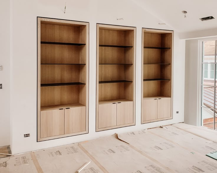 three empty bookshelves sitting in the middle of a room under construction with no one around them