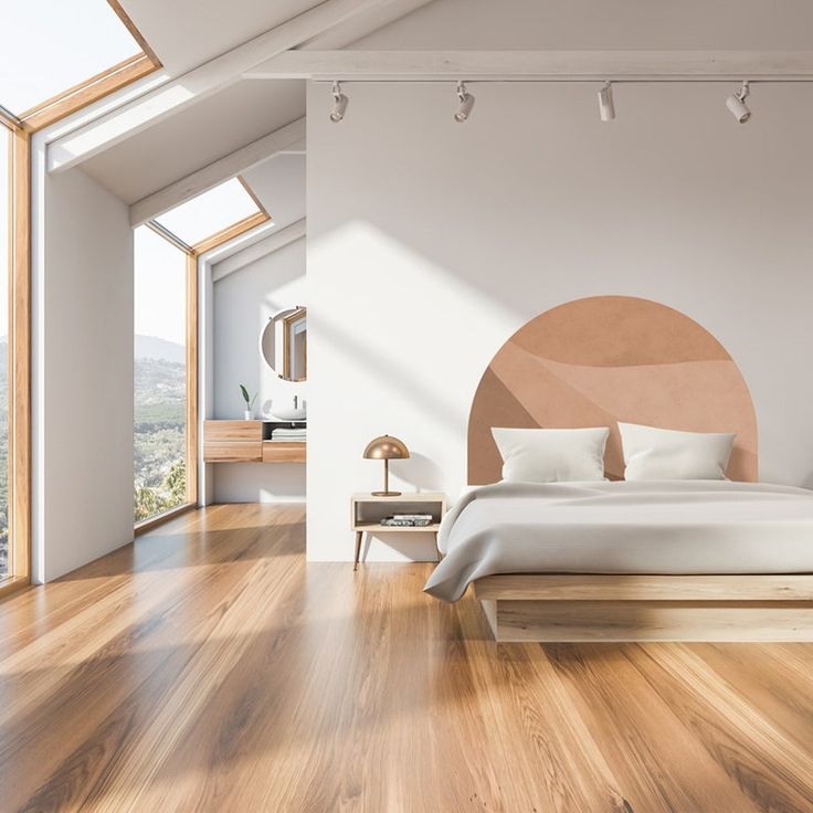 a bedroom with wood flooring and white walls, along with a bed in the middle