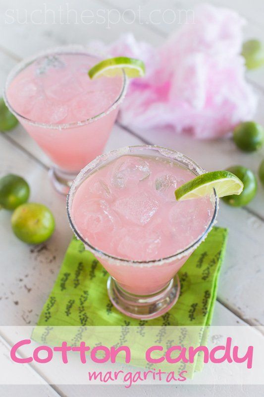 two glasses filled with pink margaritas on top of a green napkin next to limes