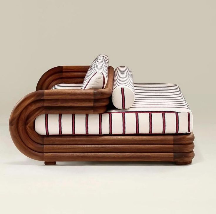 a bed made out of wood and white sheets with striped pillows on top of it