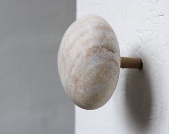 a white door knob with a wooden handle on the side of a building or house