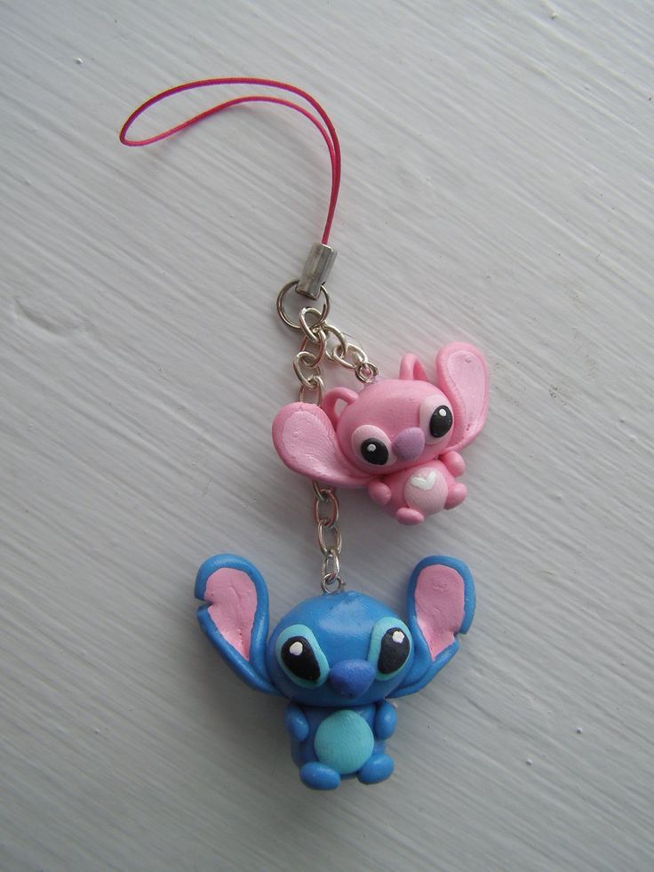 two little blue and pink elephants are hanging from a keychain