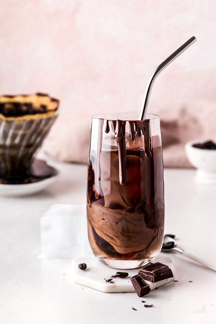 a glass filled with ice and chocolate on top of a table