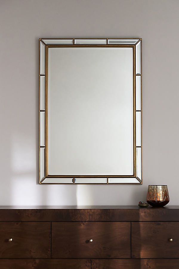 a mirror sitting on top of a wooden dresser