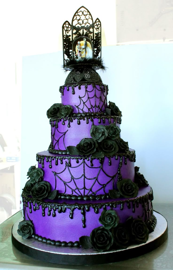 a three tiered cake with purple frosting and black roses on top is decorated with a gothic theme