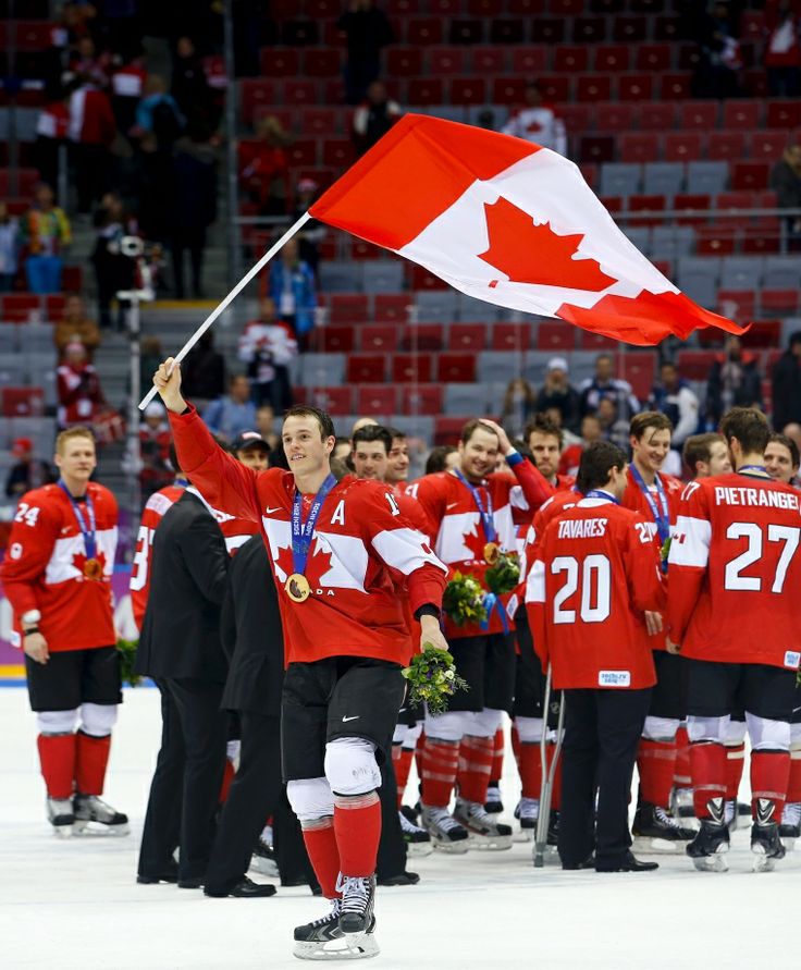 the canadian men's ice hockey team celebrates with their gold medal and flag at the 2012 winter olympics