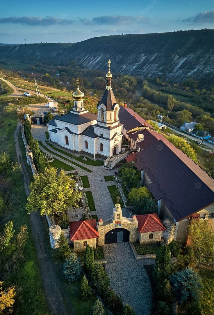 an aerial view of a church surrounded by trees