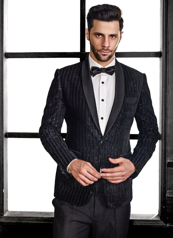 Elevate your formal wardrobe with the exquisite Black Embroidery Velvet Tuxedo Set, a perfect blend of classic elegance and modern flair. Crafted from luxurious velvet, this black jacket showcases intricate thread embroidery and shimmering sequins in a refined herringbone pattern, adding both texture and a subtle shine. Paired with matching black trousers, this ensemble offers a polished and sophisticated look. Ideal for wedding receptions, cocktail events, or sangeet nights, this tuxedo is desi Velvet Tuxedo, Indian Wedding Wear, Black Embroidery, Wedding Receptions, Thread Embroidery, Black Trousers, Herringbone Pattern, Wedding Wear, Classic Elegance