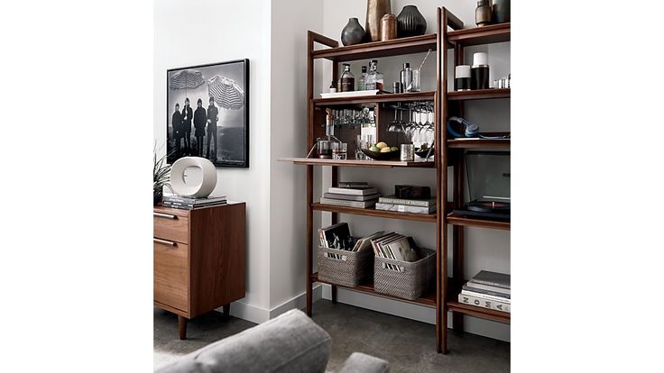 a living room filled with lots of furniture next to a wall mounted art piece on the wall