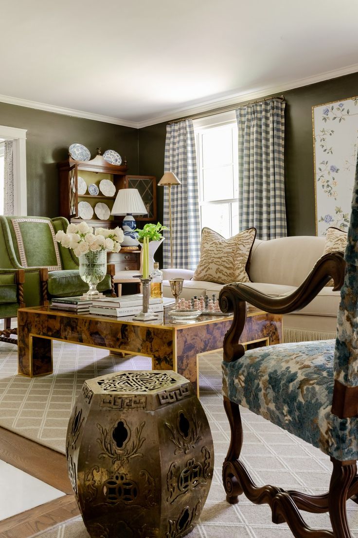 a living room filled with furniture next to a window covered in blue and white curtains