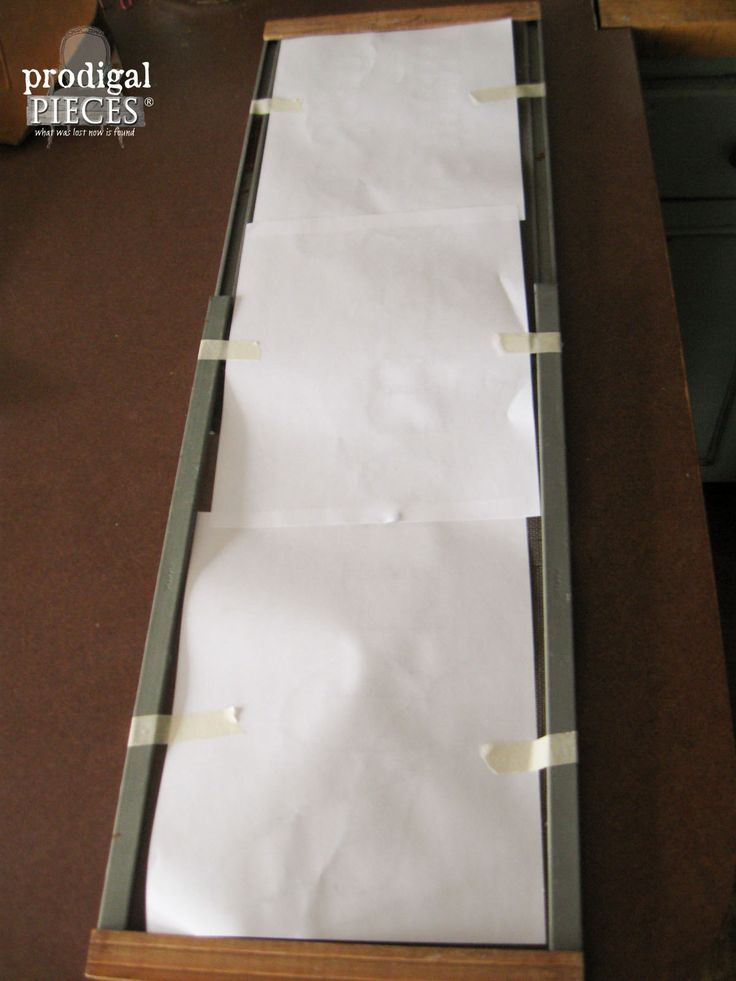 two pieces of paper are taped to the bottom of a drawer with tape on it