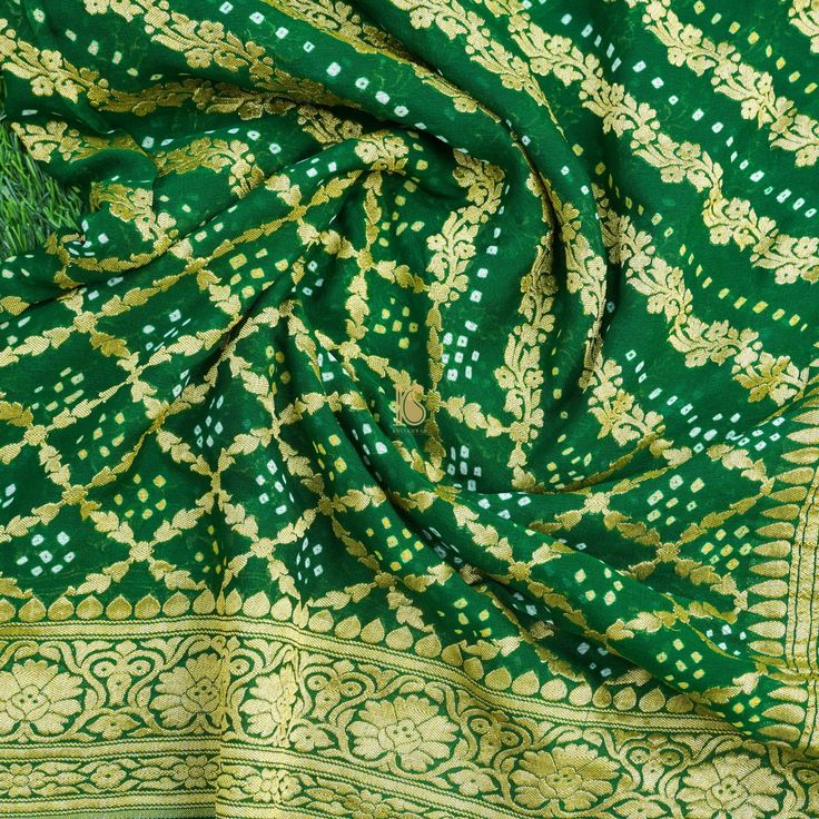 Experience the exquisite charm of Khinkhwab's Bandhani Banarasi saree. This beautiful piece effortlessly combines rich sophistication with comfort, making it an ideal all-weather attire. Elevate your style with this timeless creation. Luxury Bandhani Print Georgette Saree, Traditional Green Slub Silk Pre-draped Saree, Bollywood Style Green Pre-draped Saree With Motifs, Elegant Bandhani Print Pre-draped Saree For Festive Occasions, Elegant Festive Pre-draped Saree With Bandhani Print, Elegant Festive Pre-draped Bandhani Saree, Elegant Bandhani Print Blouse Piece For Diwali, Green Jamawar Pre-draped Saree For Festivals, Elegant Pre-draped Saree With Bandhani Print