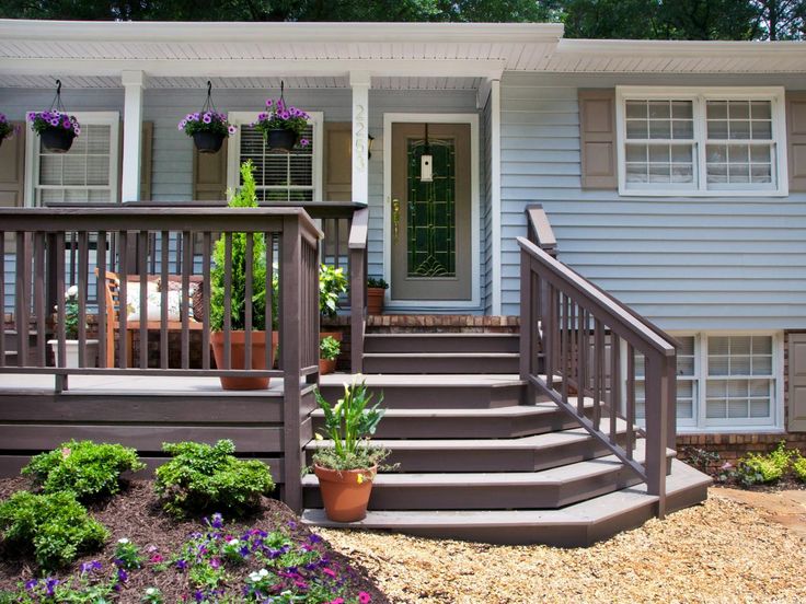 a house with steps leading to the front door and flowers in pots on the porch